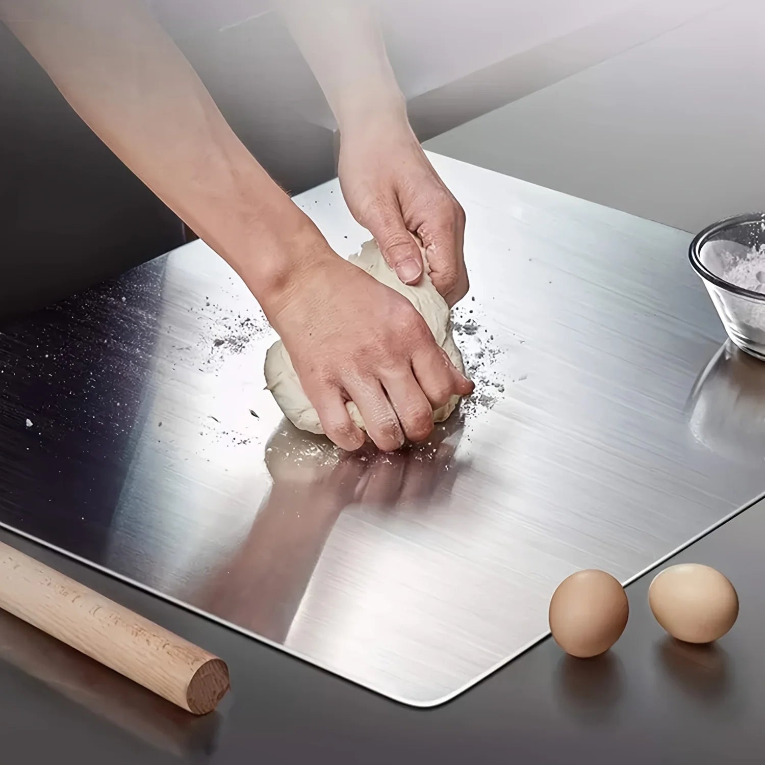 Préparation de pâte sur une planche à découper en acier inoxydable de qualité supérieure avec des œufs et un rouleau à pâtisserie