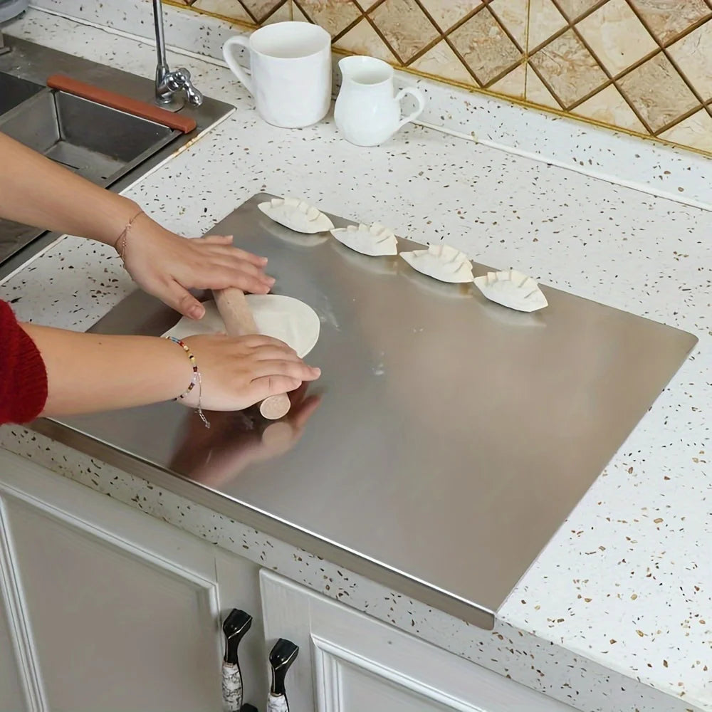 Planche à découper en acier inoxydable de qualité supérieure utilisée pour préparer de la pâte dans une cuisine moderne