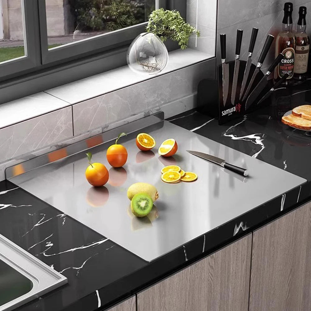 Planche à découper en acier inoxydable de qualité supérieure sur un plan de travail moderne avec des fruits frais
