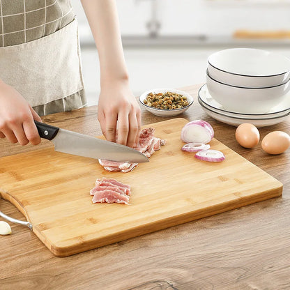 Planche à Découper en Bambou Szkoy avec des mains coupant de la viande et des oignons à côté