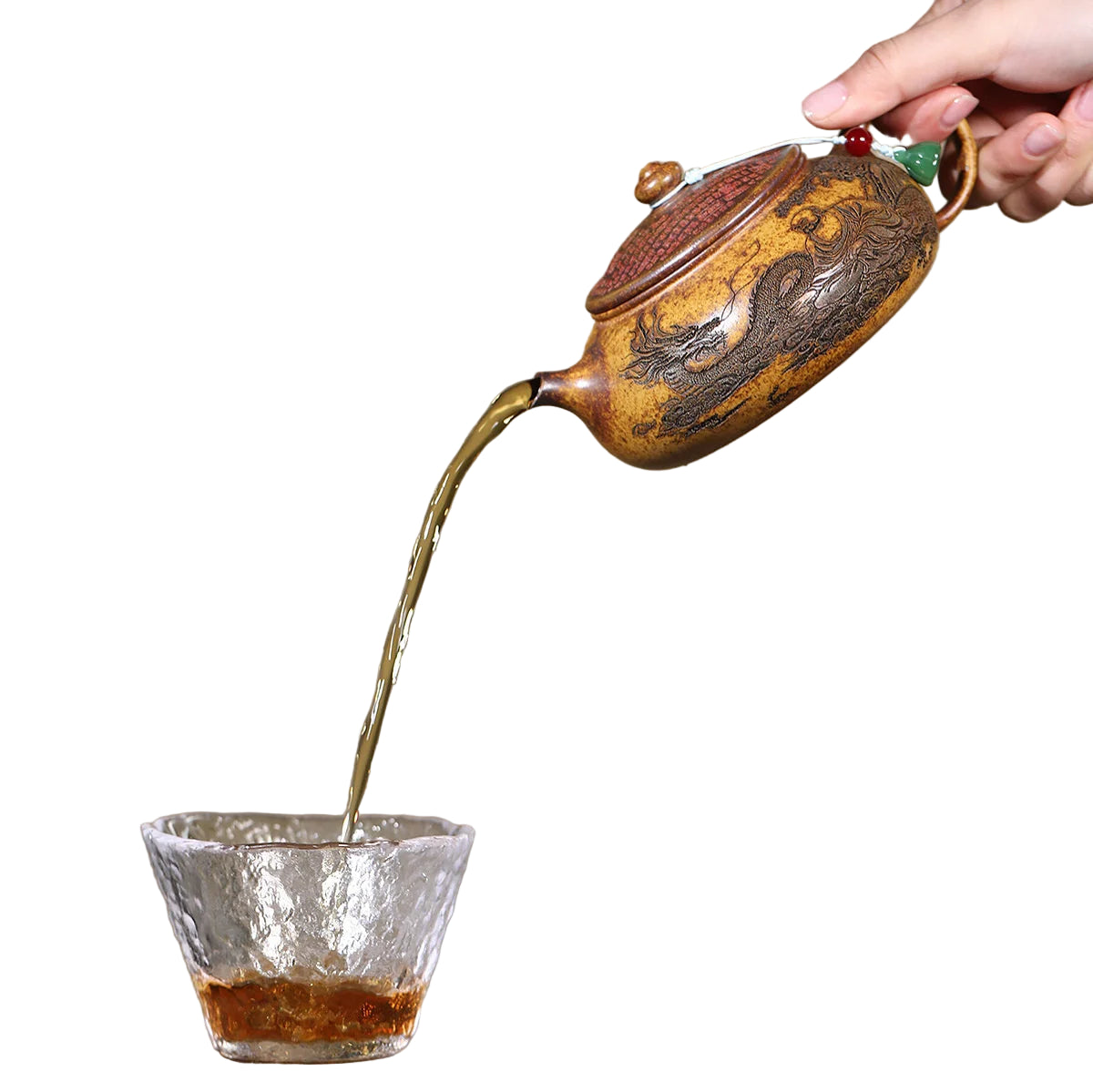 Théière Yixing Arhat Hanjiang en céramique versant du thé dans un verre transparent