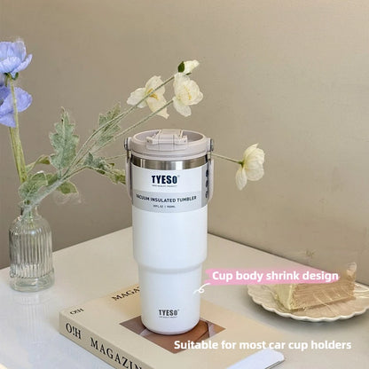 Mug isotherme inox avec anse – 750ml à 1200ml blanc TYESO sur table avec fleurs et livre