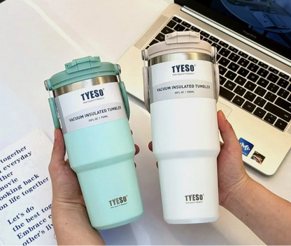 Deux mugs isothermes TYESO tenus à la main près d'un ordinateur portable Mug isotherme inox avec anse – 750ml à 1200ml