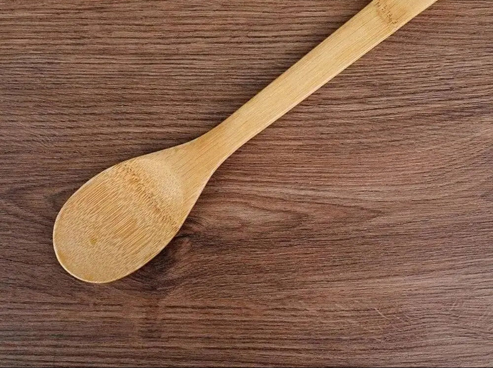 Ustensiles de cuisine en bambou 7 pièces antiadhésives écologiques avec une cuillère en bois sur un plan de travail