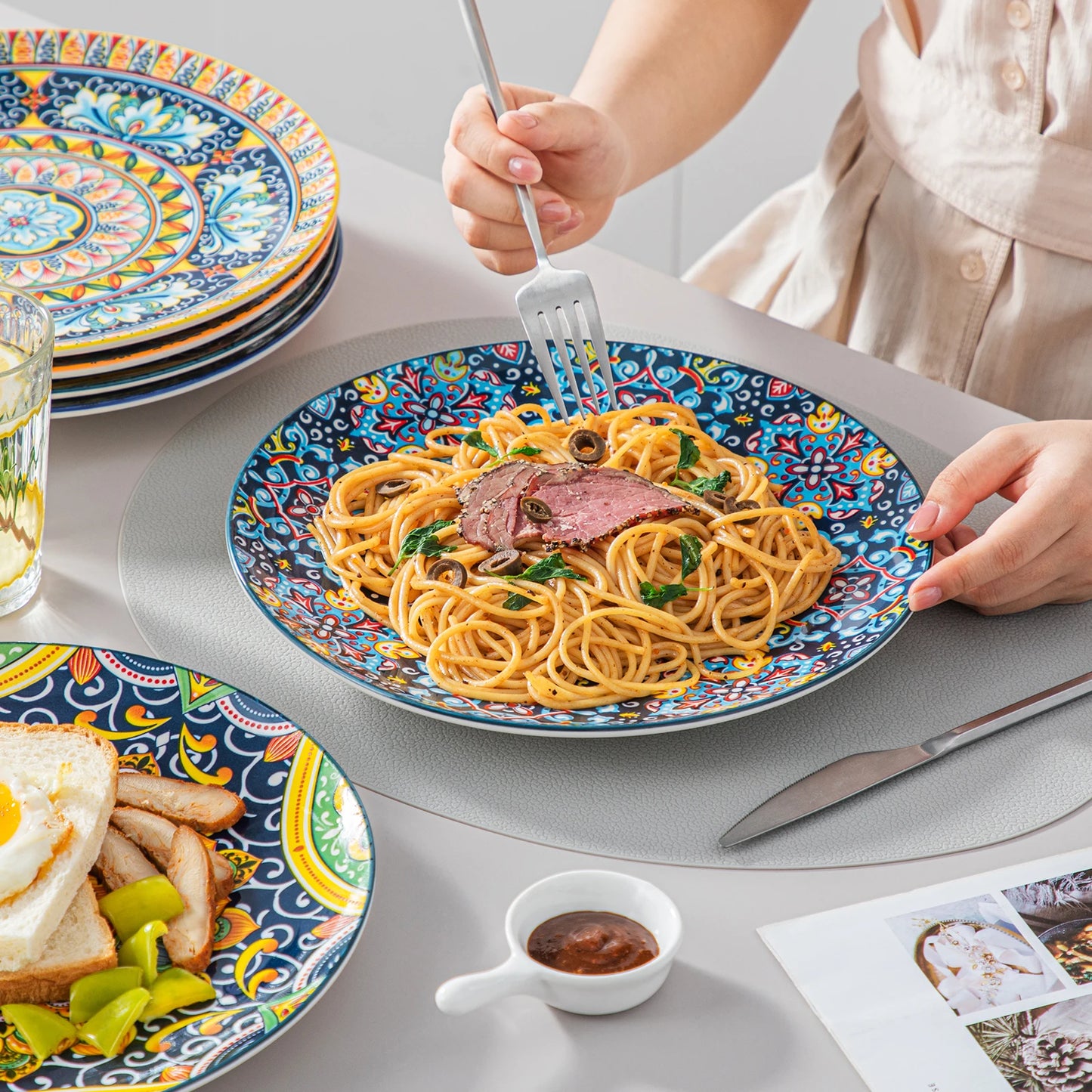 Service de table MALACASA en porcelaine avec assiettes colorées et spaghetti savoureux sur la table